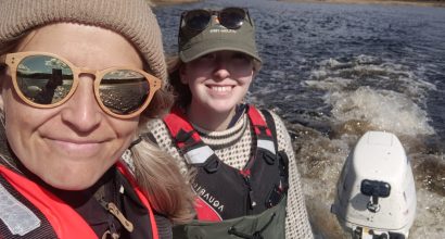 Elina Kasvi and Linnea Blåfield driving a research boat at a Finnish river