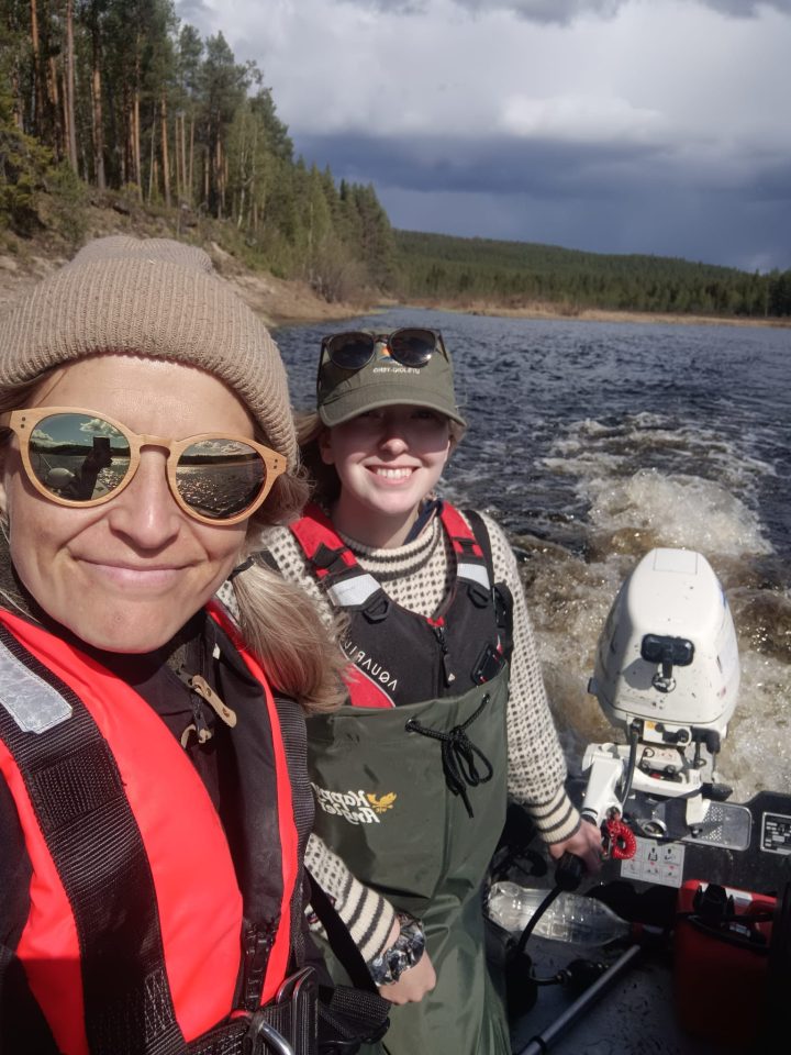 Elina Kasvi and Linnea Blåfield driving a research boat at a Finnish river
